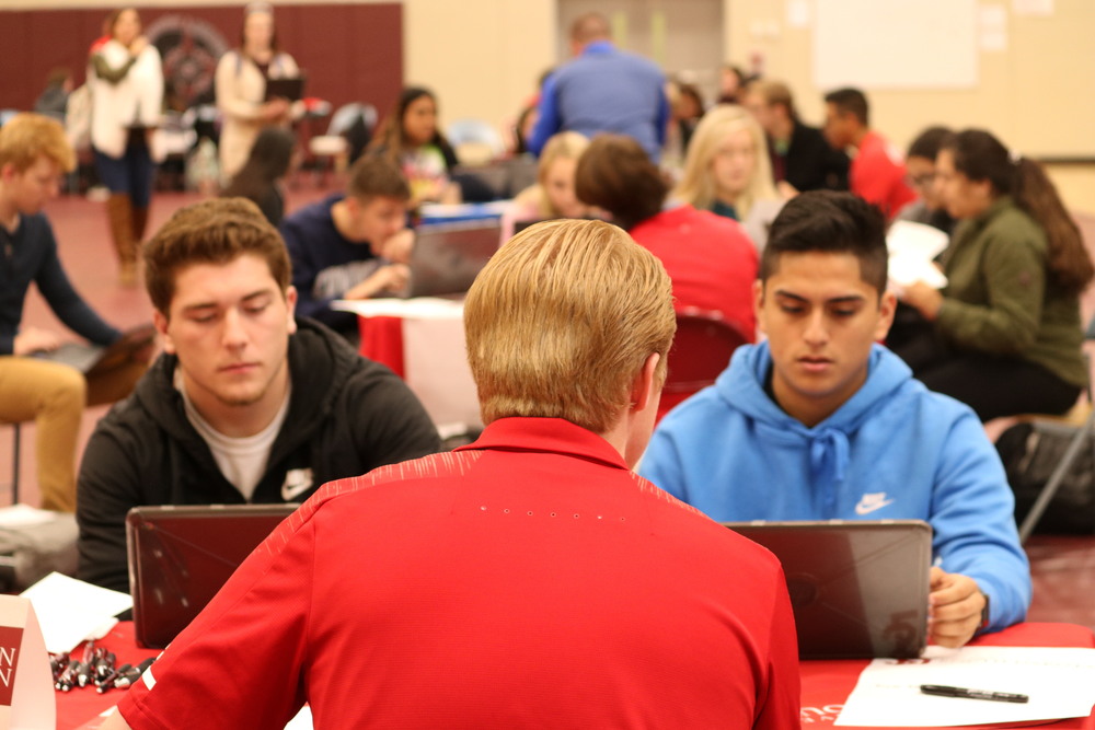 University of South Dakota representative Rush Milne, foreground, goes over the online application process with seniors Anthony Deanda, left, and Carlos Rodriquez on Tuesday at the Apply 2 College event at CHS. 