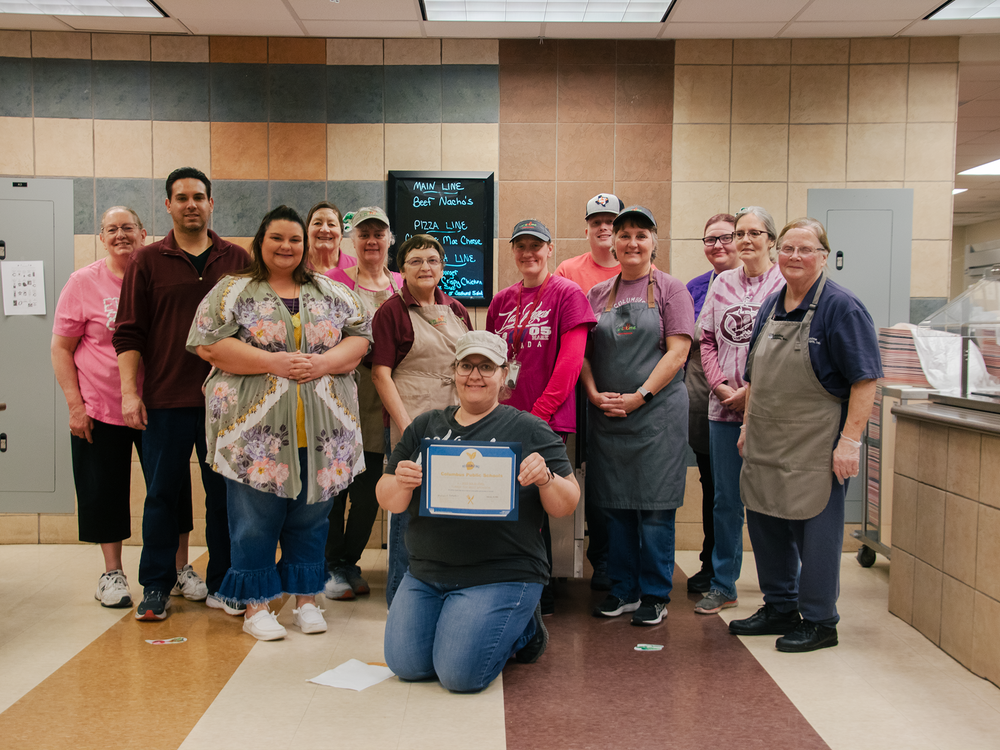Team members of Columbus Middle School Food Service pose with the USDA Turnip The Beet certificate.