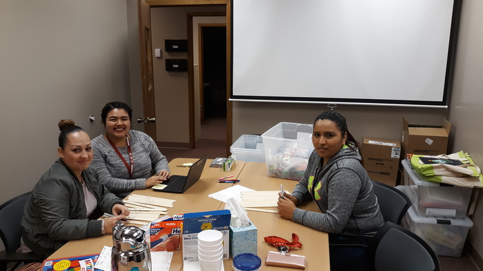 EL Office Assistant and parent volunteers create bilingual resources packs.